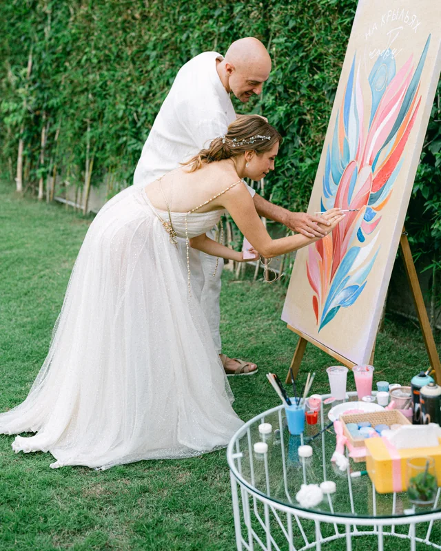The couple painting a canvas at their reception